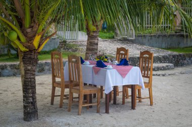 Plajda sandalyeli tatil masası.