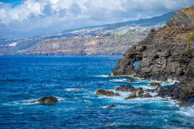 Tenerife, Canaria Adaları, İspanya 'da Puerto de la Cruz' daki Martianez Körfezi yakınlarındaki kayalıklardaki Atlantik kırıklarından gelen dalgalar taşlara çarpıyor.