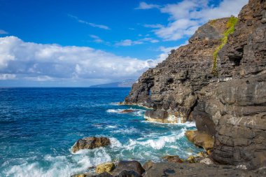 Tenerife, Canaria Adaları, İspanya 'da Puerto de la Cruz' daki Martianez Körfezi yakınlarındaki kayalıklardaki Atlantik kırıklarından gelen dalgalar taşlara çarpıyor.