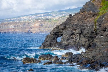 Tenerife, Canaria Adaları, İspanya 'da Puerto de la Cruz' daki Martianez Körfezi yakınlarındaki kayalıklardaki Atlantik kırıklarından gelen dalgalar taşlara çarpıyor.