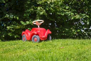 Park yerinde kırmızı oyuncak araba. 