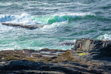 İrlanda 'da taştan kıyılarda okyanus dalgaları kırılıyor