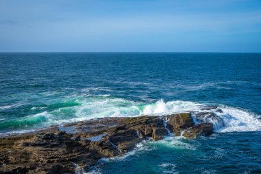 İrlanda 'da taştan kıyılarda okyanus dalgaları kırılıyor