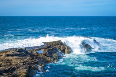 İrlanda 'da taştan kıyılarda okyanus dalgaları kırılıyor