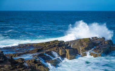 İrlanda 'da taştan kıyılarda okyanus dalgaları kırılıyor