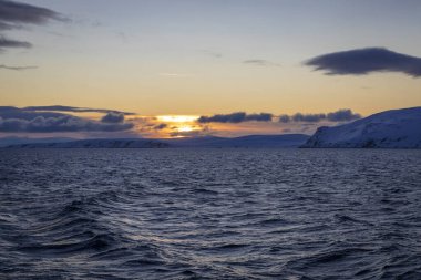 Norveç 'te kışın deniz kıyısında güzel gün batımı