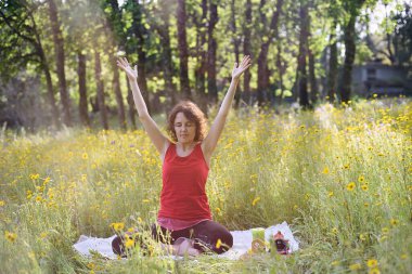 Covid 19 'dan sonra sarı çiçek tarlasında yoga yapan bir kadın..