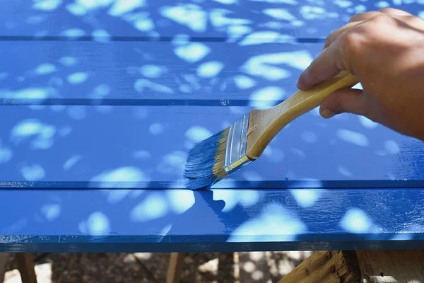 Hand painting wooden board in blue.