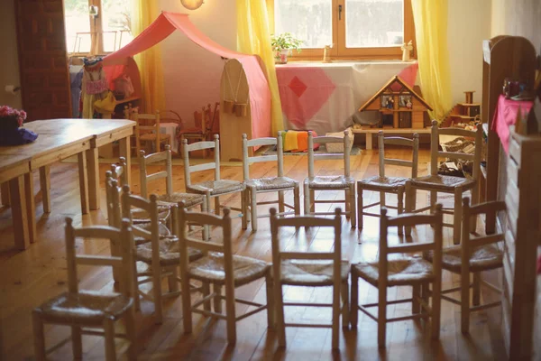 Wooden chairs placed in a circle at Waldorf school.