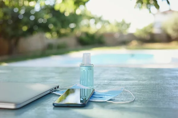 Summer background with gel, mask, mobile phone and computer in the garden.