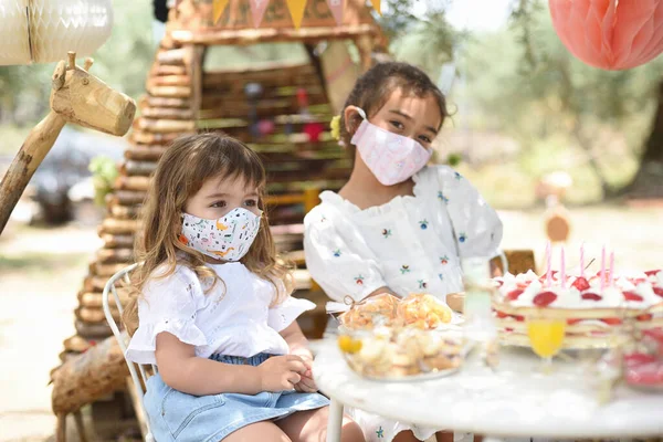 İki güzel kız doğum günü partisinde yeni normal ve koruyucu maskeleriyle eğleniyor..