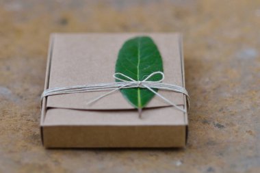 Defne yaprağı ve kabloyla süslenmiş karton kutu..