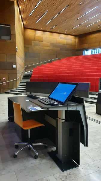 Empty modern university auditorium. The university auditorium is ready to receive students. Lecturer place with comuter and projector. Higher education concept. Online education. Distance education. Vertical frame