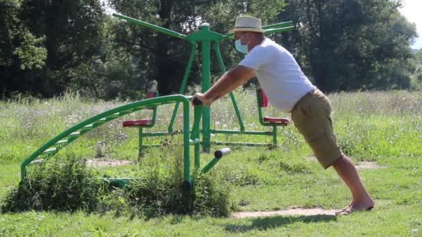 Hombre Mediana Edad Con Sombrero Máscara Médica Haciendo Ejercicio Gimnasio — Vídeo de stock