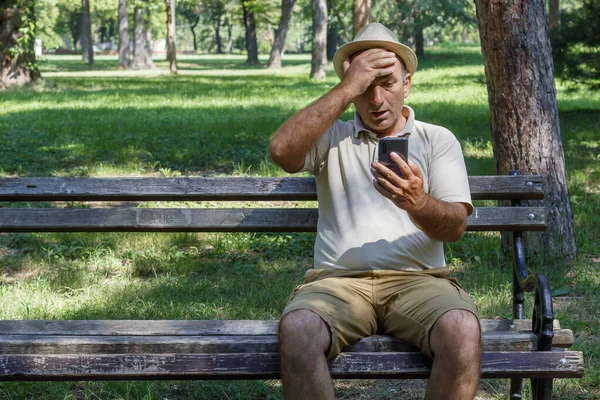 Orta Yaşlı Bir Adam Bankta Oturuyor Tek Eliyle Akıllı Telefonu — Stok fotoğraf