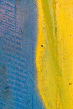 Yarı sarı, yarı mavi yıpranmış beton duvar dokusu.