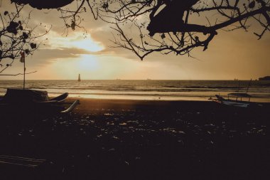 Gün batımında siluet tekne ve ağaç, Cilacap, Endonezya