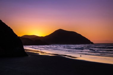 Wharariki Sahili, Golden Bay, Tasman, Güney Adası, Yeni Zelanda 'da Renkli Günbatımı