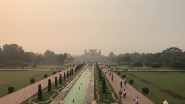 Agra, Índia, 10 de novembro de 2019, Taj Mahal, um longo canteiro de flores com turistas a caminho da mesquita — Vídeo de Stock