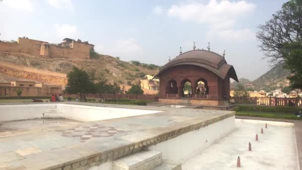 Jaipur, indien, 05. November 2019, amer fort, Touristen sitzen auf einer Bank in der Nähe eines Festungsgebäudes — Stockvideo