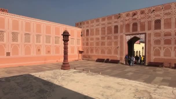 Jaipur, Indien - 04 november 2019: City Palace turister går förbi väggarna i en rosa byggnad — Stockvideo