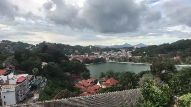 Kandy, Sri Lanka, uitzicht op gebouwen langs het meer vanaf de berg — Stockvideo
