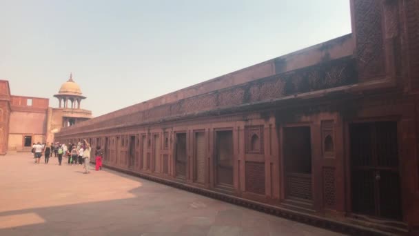 Agra, India, 10 novembre 2019, Agra Fort, i turisti camminano lungo la struttura in mattoni rossi — Video Stock