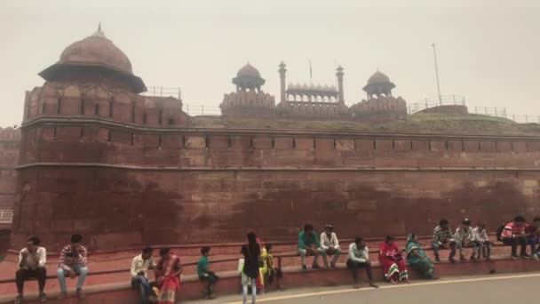 Нью-Дели, Индия, 11 ноября 2019 года, Красный Форт, туристы сидят перед входом — стоковое видео
