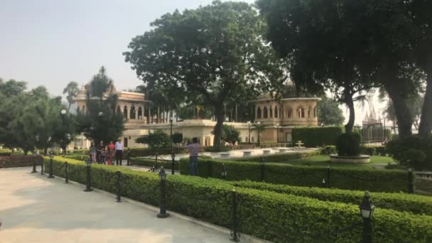 Udaipur, India - 12 novembre 2019: I turisti di Jag Mandir passeggiano nel giardino verde — Video Stock