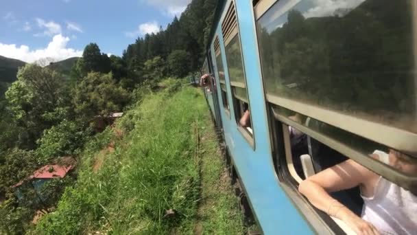 Ella, Srí Lanka, 23. listopadu 2019, z okna vlaku vykoukne turista — Stock video