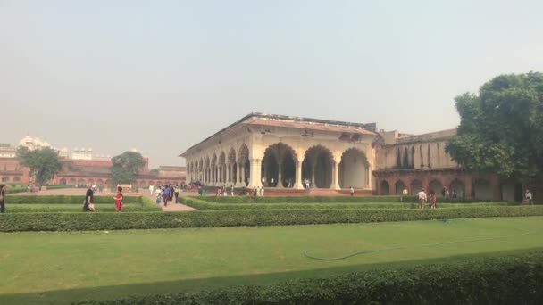 Agra, India, November 10, 2019, Agra Fort, tourists walk along the green bushes — 图库视频影像