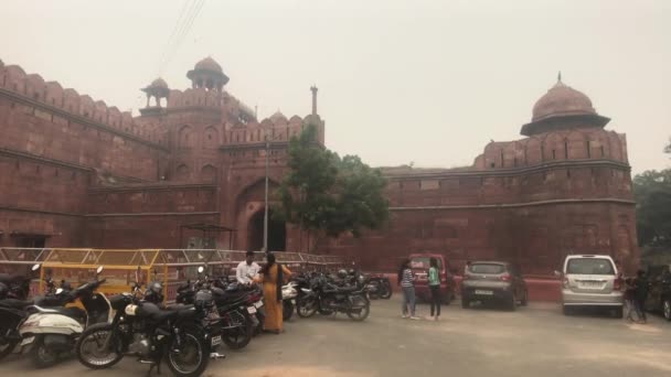 Νέο Δελχί, Ινδία, 11 Νοεμβρίου 2019, οι τουρίστες στέκονται στο πάρκινγκ μπροστά από την είσοδο του φρουρίου — Αρχείο Βίντεο