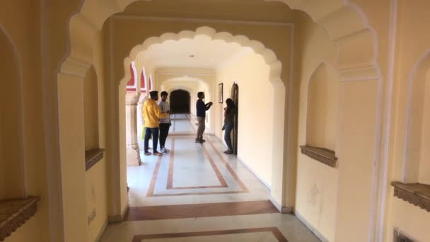 Jaipur, Indie - 4. listopadu 2019: Turisté z Městského paláce stojí na chodbě krásné budovy — Stock video