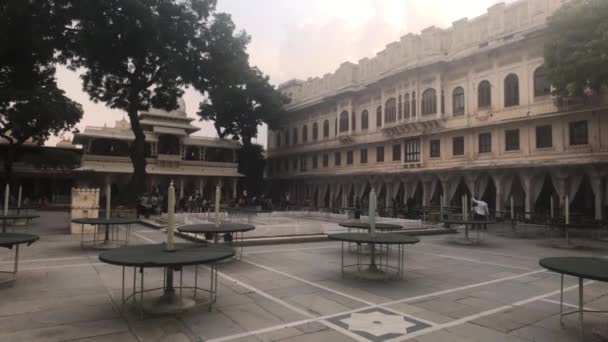 Udaipur, India - 2019. november 13.: A Városi Palota turistái pihenhetnek a történelmi épület udvarán 4. rész — Stock videók