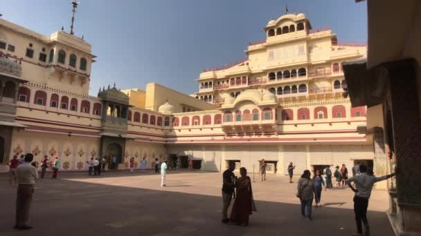 Jaipur, India - 04 de noviembre de 2019: Los turistas del Palacio de la Ciudad están a la sombra del edificio — Vídeo de stock