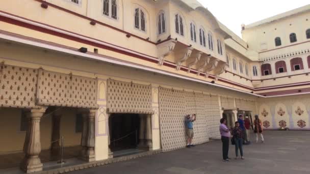 Jaipur, Indie - 04 listopada 2019: Miejska grupa turystów ukryta przed słońcem w cieniu budynku — Wideo stockowe