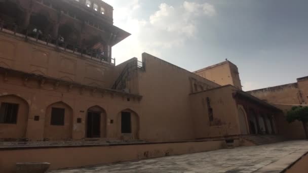 Jaipur, India, 2019. november 05., Amer erőd, egy turista sétál végig egy régi épület falán — Stock videók