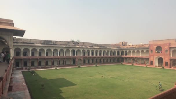 Agra, India, 10 november 2019, Agra Fort, toeristen bekijken een groen gebied in een oud fort — Stockvideo
