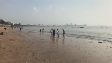 Mumbai, India - November 10, 2019: Marine Drive tourists walk on the beach part 7