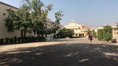 Jaipur, India - November 04, 2019: City Palace and a tourist passing by trees