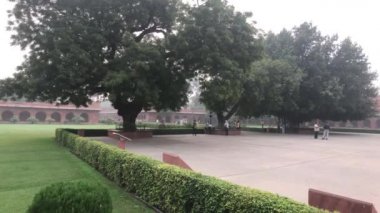 Agra, Hindistan, 10 Kasım 2019, Taj Mahal, turistler tapınaktaki ağaçların yanında yürüyorlar.