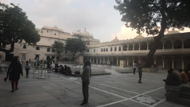 Udaipur, India - 13 de noviembre de 2019: Los turistas del Palacio de la Ciudad se relajan en el patio del edificio histórico parte 5 — Vídeos de Stock