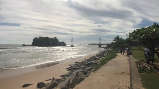 Matara, Sri Lanka, 25 november 2019, Beach Road, toeristen tegen de achtergrond van de zee en het eiland — Stockvideo