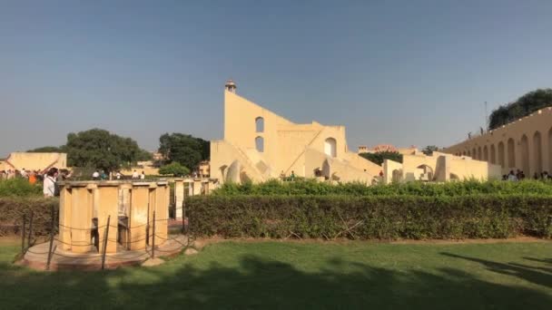 Jaipur, India - 04 de noviembre de 2019: Los turistas de Jantar Mantar se esconden del sol a la sombra de las estructuras históricas parte 2 — Vídeo de stock