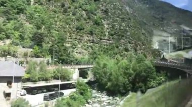 Andorra, ormanın yakınındaki tren raylarından geçen bir tren.