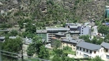 Andorra, arkasında dağ olan büyük beyaz bir bina.
