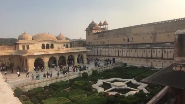 Jaipur, Indie, 5. listopadu 2019, Amer Fort turisté procházejí areálem na pozadí zelených keřů část 3 — Stock video