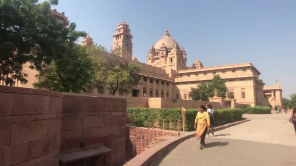 Jodhpur, India - November 06, 2019: Umaid Bhawan Palace tourists pass by neat buildings part 2 — Stock Video