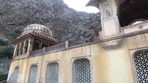 Jaipur, India - Galta Ji, monkeys jump on the eaves of an old structure — Stockvideo