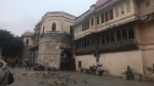 Удайпур, Индия - 12 ноября 2019 года: туристы отдыхают в тени 3-й части здания — стоковое видео